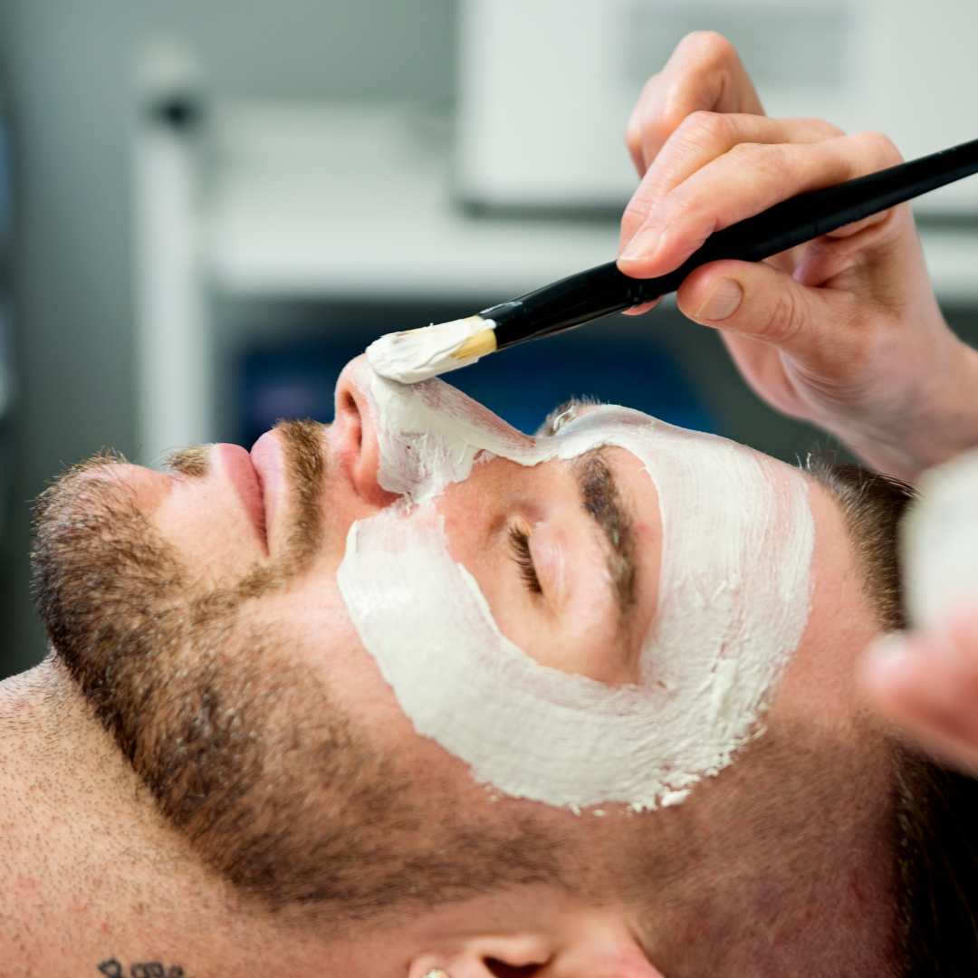 Gentleman's facial treatment with mask application in spa.